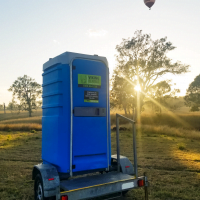 portable toilet trailer on a farm at sunrise