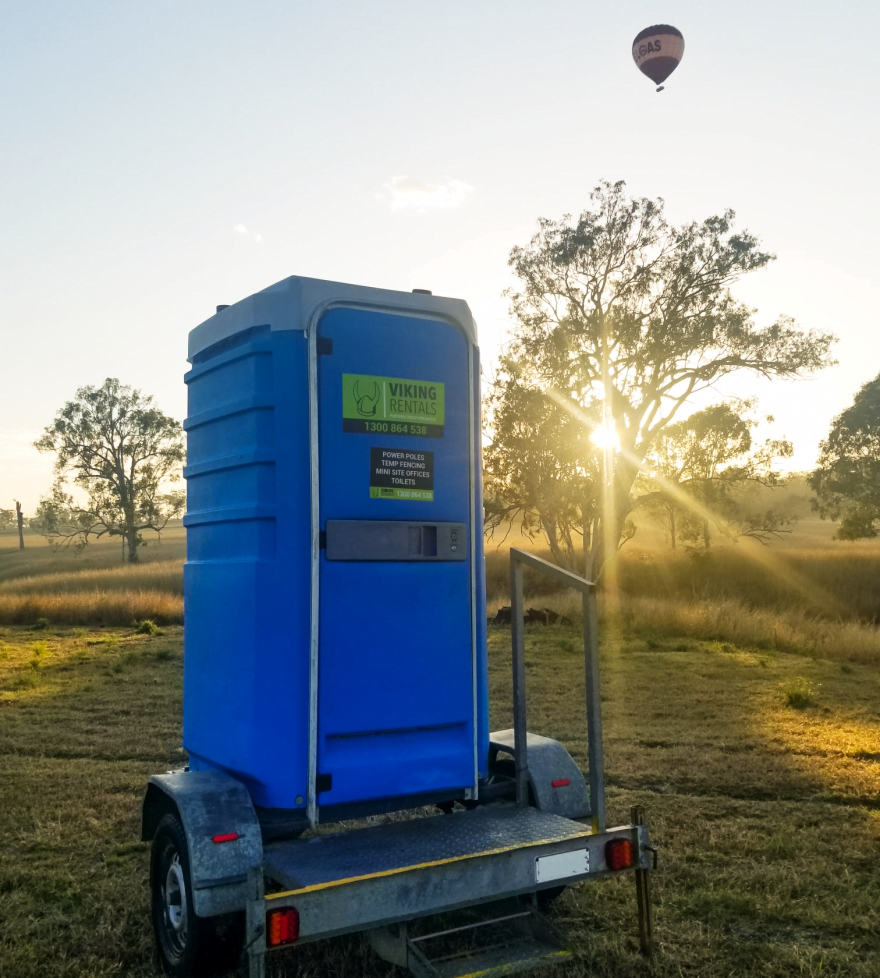 portable toilet trailer on a farm at sunrise